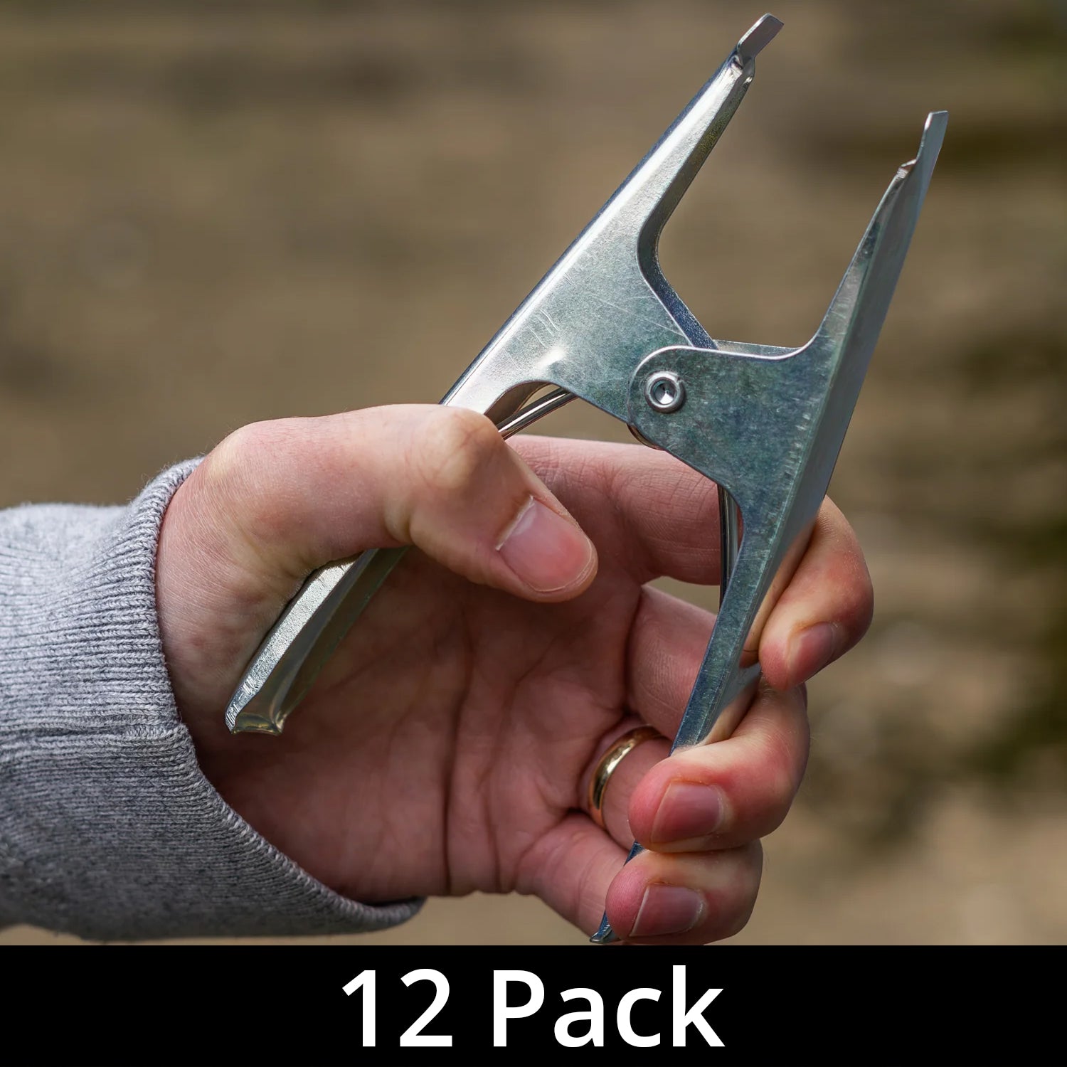 A hand holding one of the heavy duty spring clamps with a label indicating '12 Pack'.