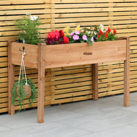 Woodside raised wooden garden bed planter with plants and vegetables, ideal for growing herbs and vegetables in a home garden.