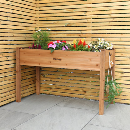 Woodside raised wooden garden bed planter with plants and vegetables, ideal for growing herbs and vegetables in a home garden.
