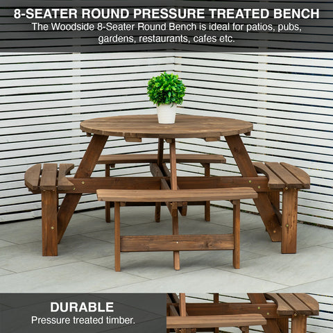 Wooden 8-seater round pressure treated bench with a plant on top, set against a slatted wall.