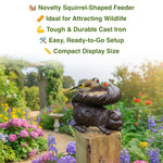 Squirrel-shaped bird feeder with a bird on top in a garden setting