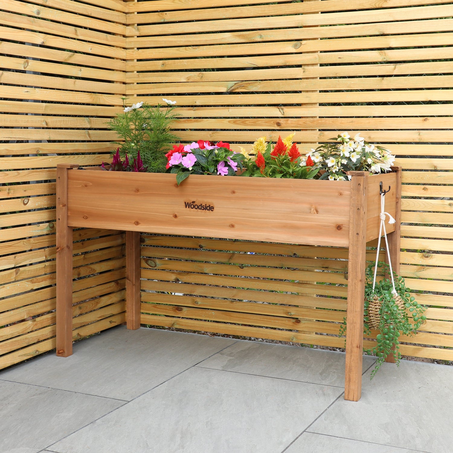 Woodside raised wooden garden bed planter with plants and vegetables, ideal for growing herbs and vegetables in a home garden.